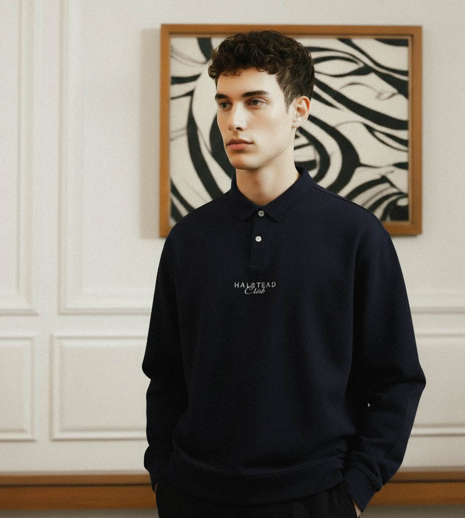 Man wearing a navy blue sweatshirt with a logo in an indoor setting