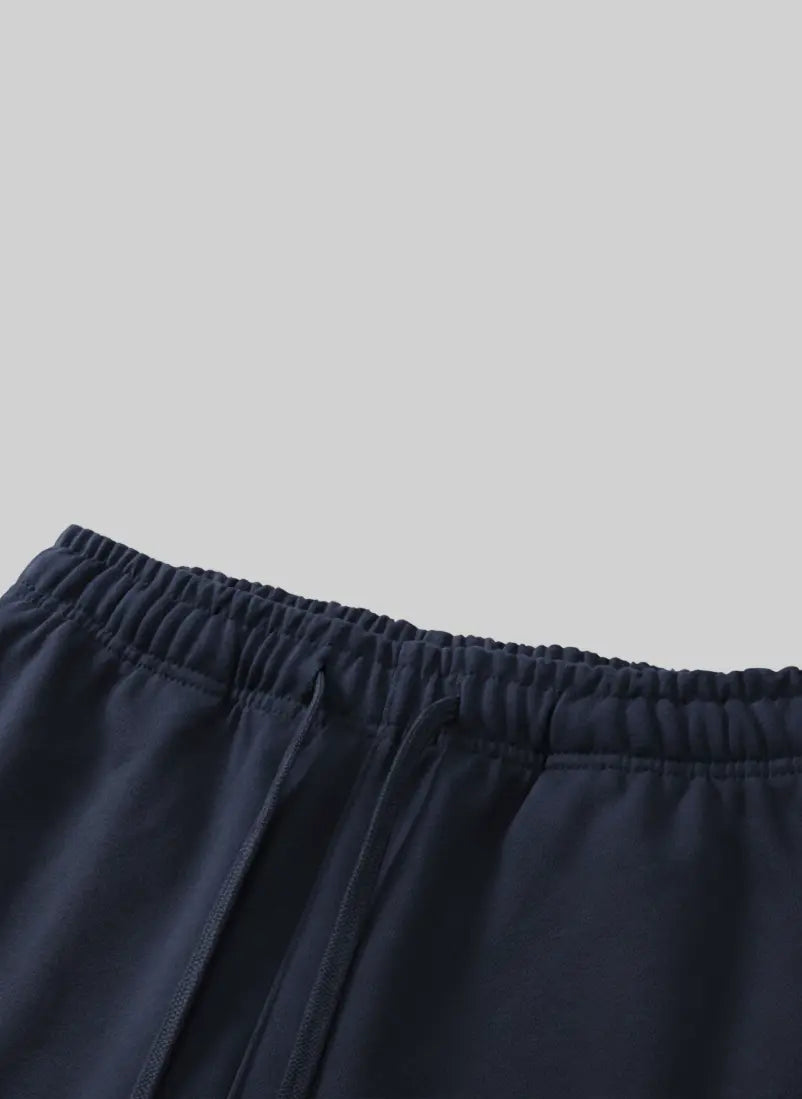 Navy blue shorts with an elastic waistband on a white background