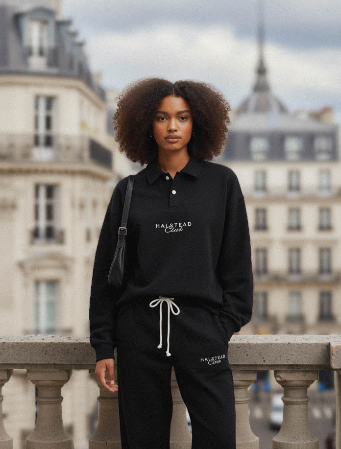 Person wearing a black outfit with 'Halstead Club' branding in an urban setting.