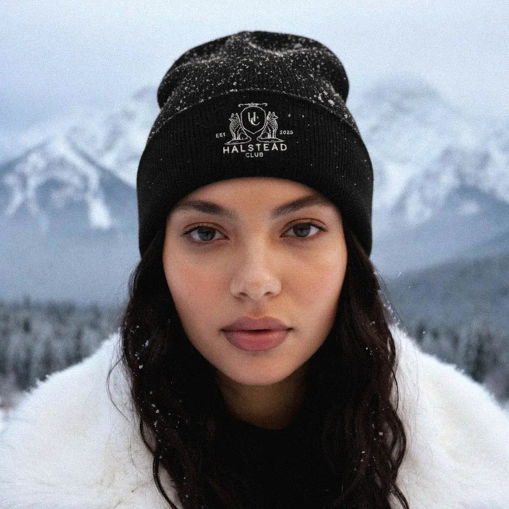 Person wearing a black beanie with 'Malstead Club' logo in a snowy landscape