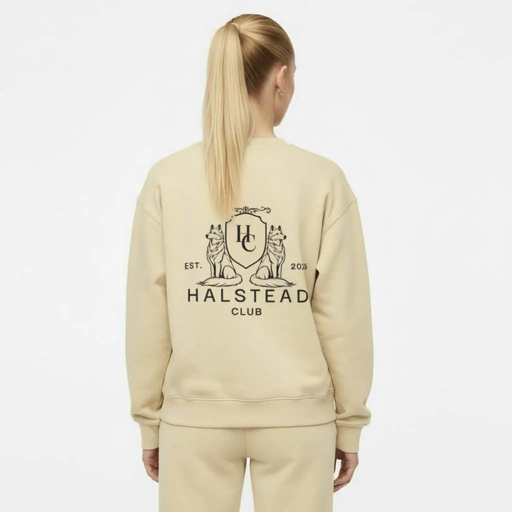 Person wearing a beige sweatshirt with 'Halstead Club' logo on the back against a white background