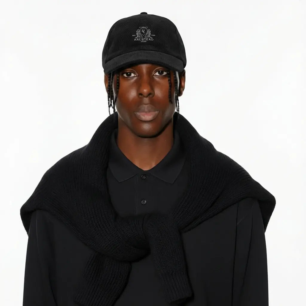 Person wearing a black cap and coat on a white background