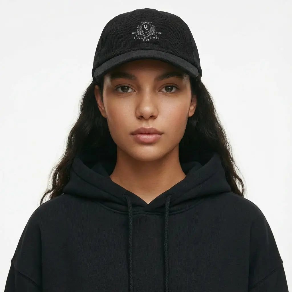 Person wearing a black hoodie and cap with a logo on a white background