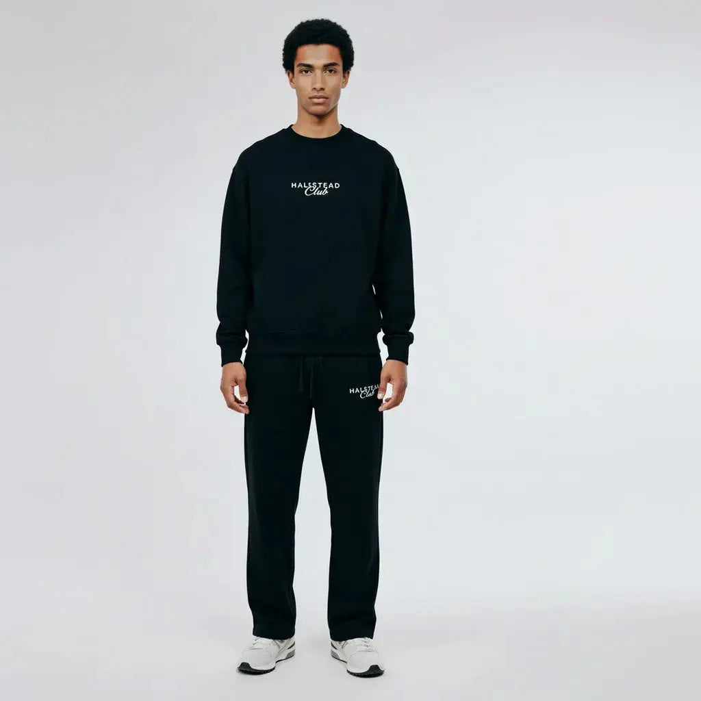Person wearing a black sweatshirt and pants with 'Malleson' branding on a white background