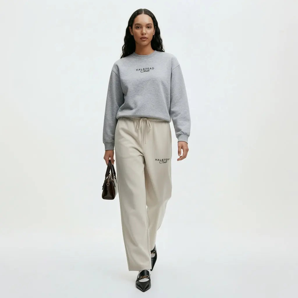 Woman wearing a gray sweatshirt and beige pants with 'Malstead' branding on a white background