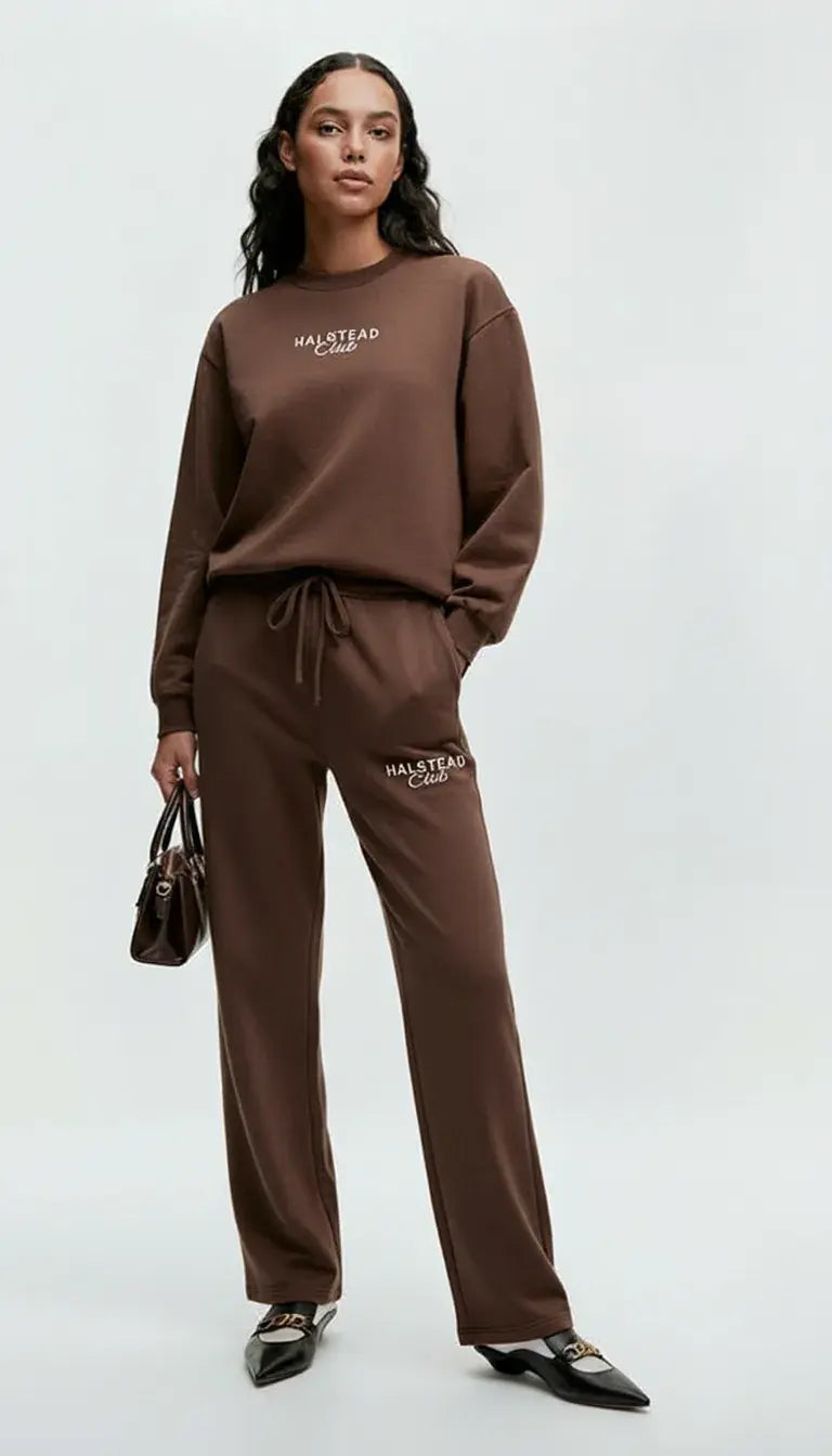 Woman wearing a brown tracksuit with 'Hallyday' branding on a white background