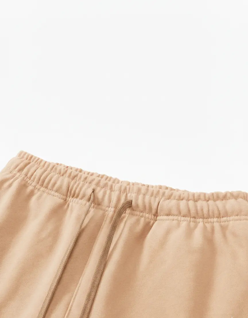 Close-up of beige shorts with a white background