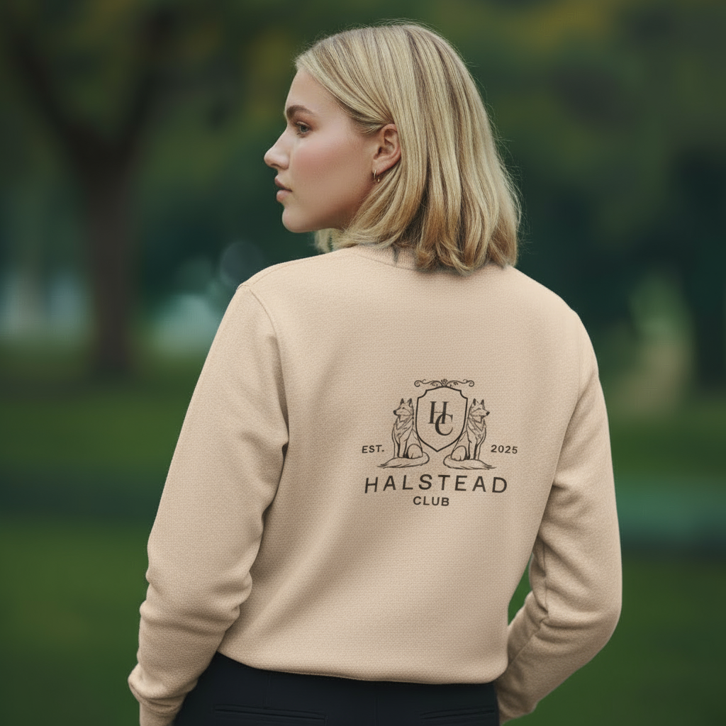 Woman wearing a beige sweatshirt with 'Halstead Club' logo outdoors