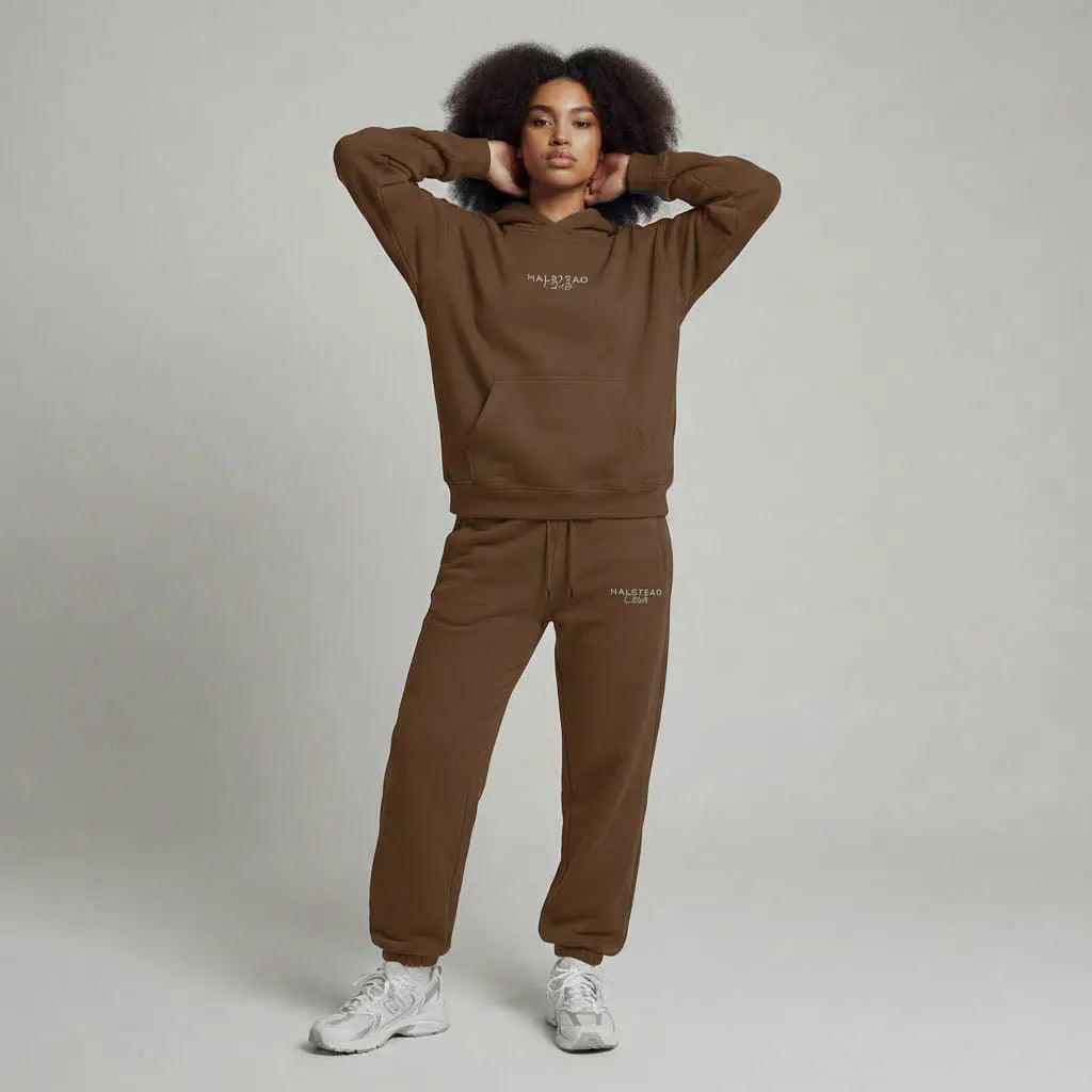 Person wearing a brown tracksuit with 'Malbon' branding on a plain background