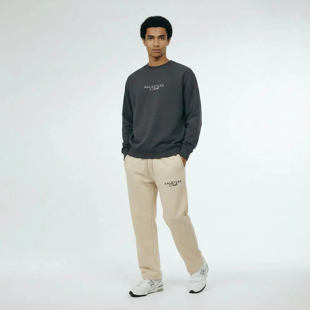 Person wearing a dark gray sweatshirt and beige pants with 'HACKETT' branding on a white background