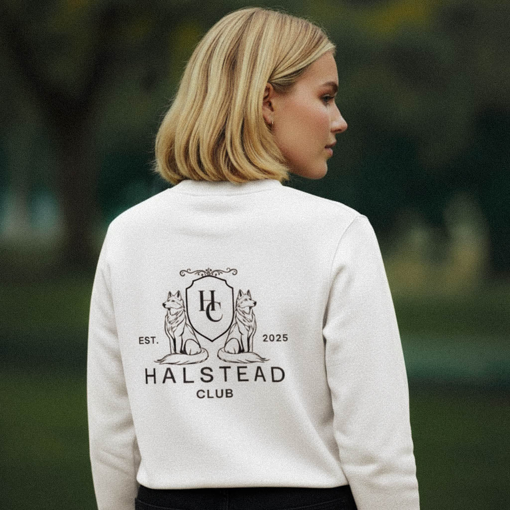 Person wearing a white sweatshirt with 'Halstead Club' logo outdoors