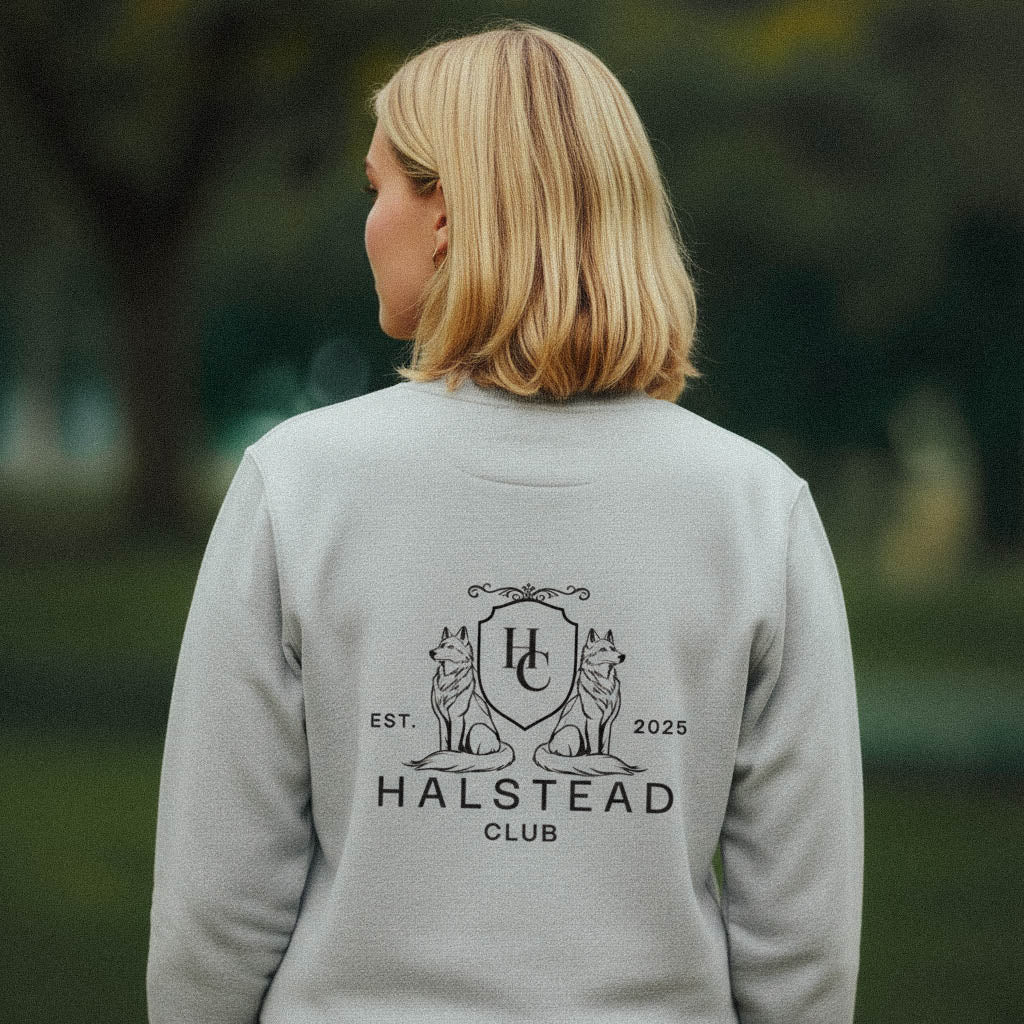 Person wearing a gray sweatshirt with 'Halstead Club' logo outdoors