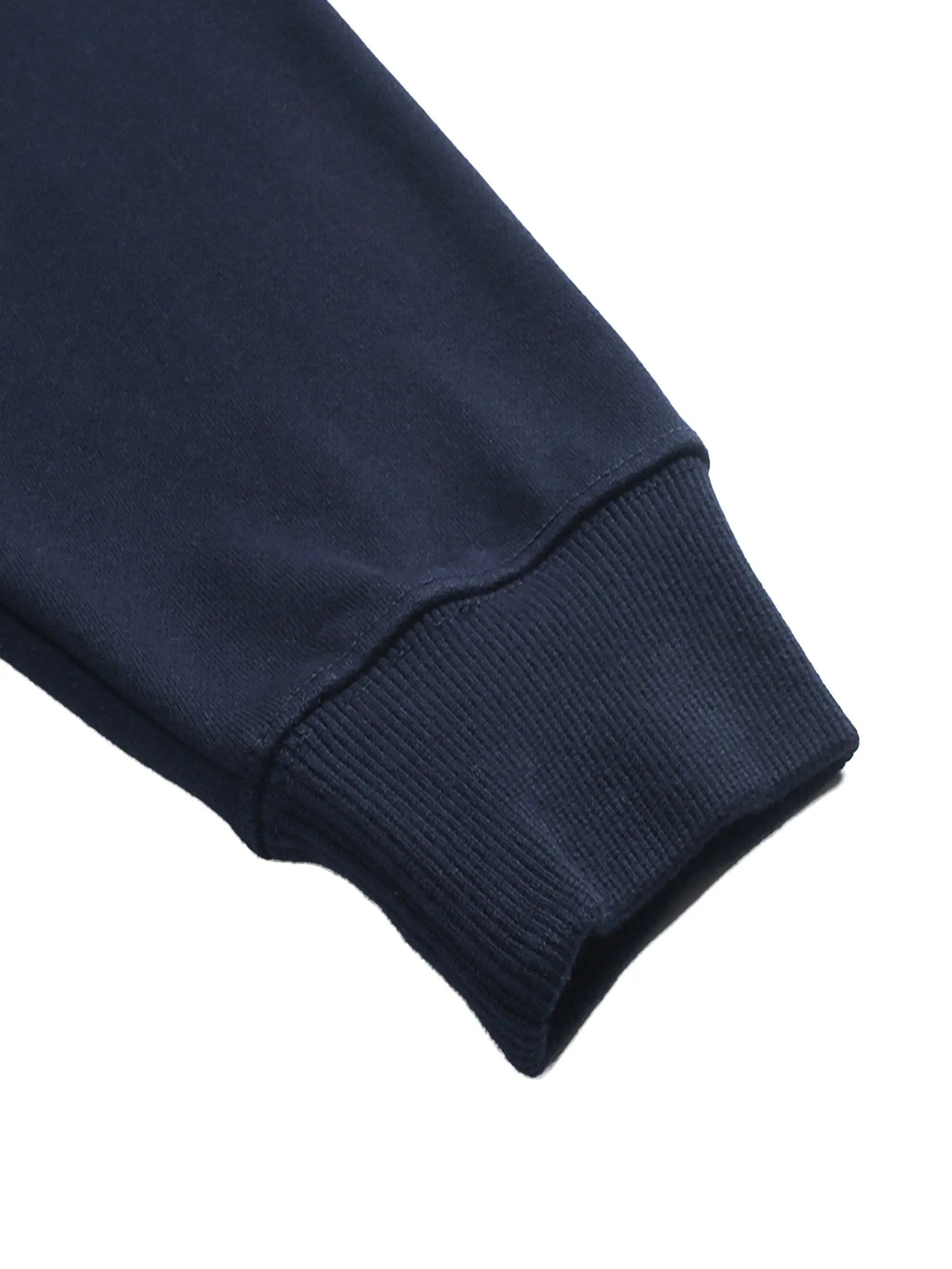 Close-up of a navy blue sweater sleeve on a white background