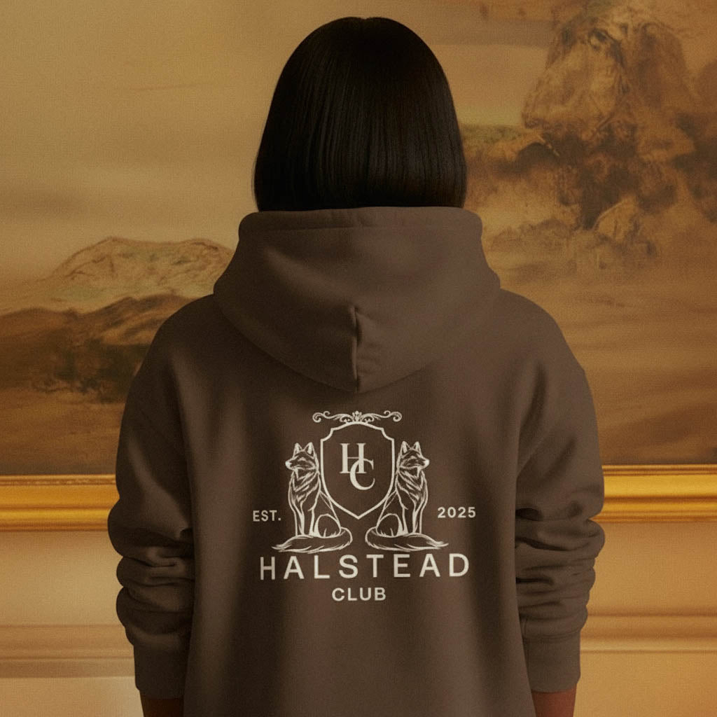 Person wearing a hoodie with 'Halstead Club' logo and text, standing in front of a painting.
