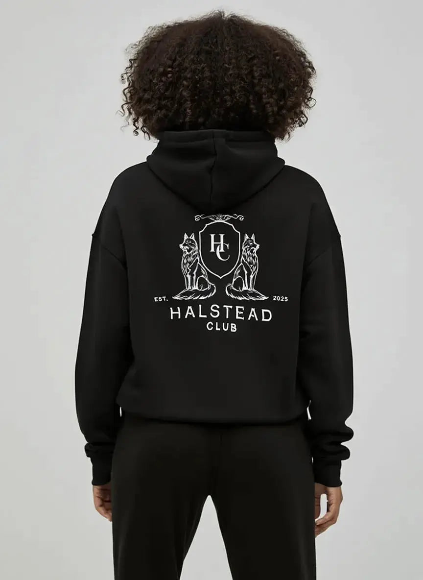Person wearing a black hoodie with 'Halstead Club' logo on the back against a plain background