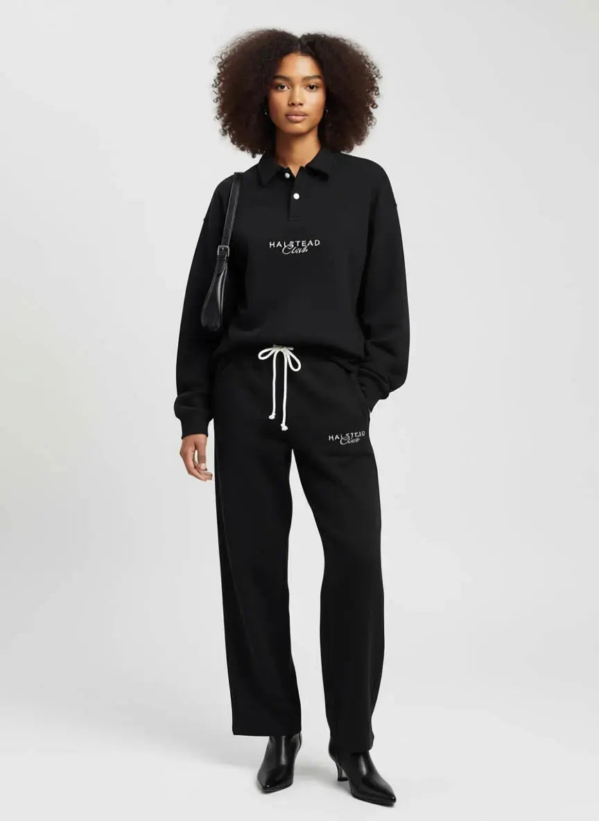 Person wearing a black tracksuit with 'Malbon' branding on a white background