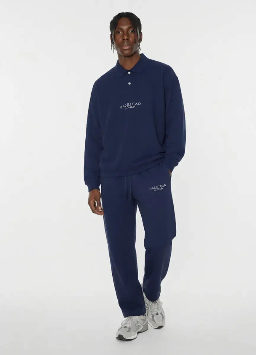 Person wearing a navy tracksuit with 'Hastead' branding on a white background